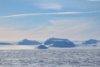 Snow-covered landscapes and surrounding waters create a picturesque scene in West Iceland.