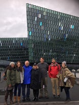 Un gruppo di persone in visita a piedi davanti alla sala concerti Harpa.