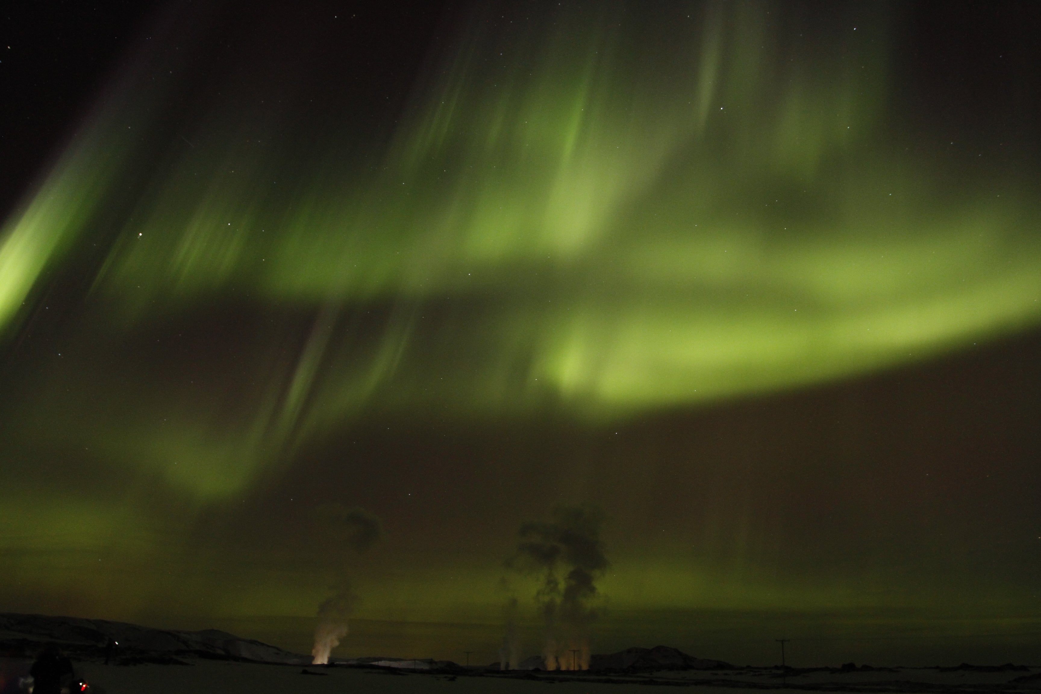 Des aurores boréales d'un vert éclatant dansant au-dessus des têtes lors d'une excursion en Islande.