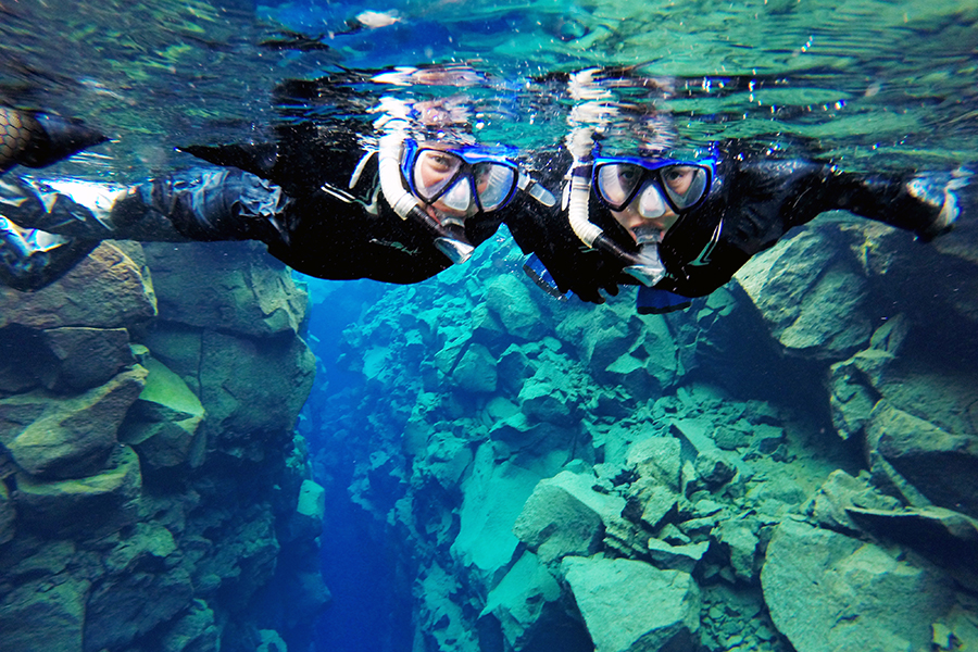 Dos personas alegres en un tour de snorkel por la Fisura de Silfra