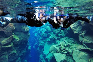 Dwóch wesołych ludzi podczas snorkelingu w szczelinie Silfra.