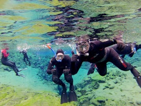 Zwei Tourteilnehmer sind begeistert vom Drysuit-Schnorcheln in Silfra.