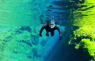 Un plongeur avec tuba déterminé nageant dans la fissure de Silfra