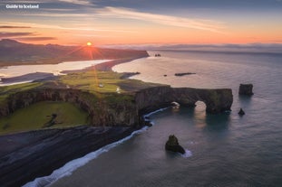 アイスランド南海岸のディルホゥラエイの断崖に沈む夕日