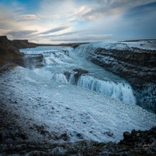 The breathtaking Gullfoss waterfall surrounded by a snow-covered landscape in winter.