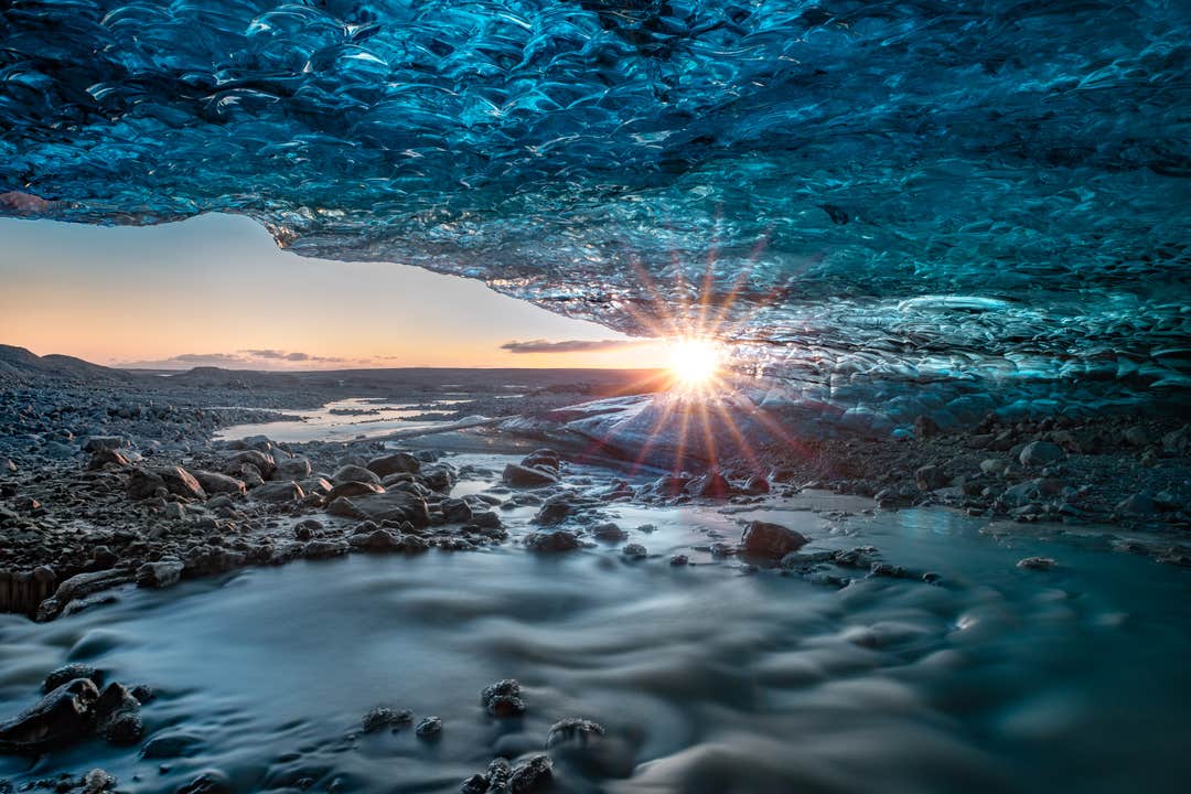 Sunlight shines through blue ice inside a crystal ice cave beneath Breidamerkurjokull Glacier in Iceland
