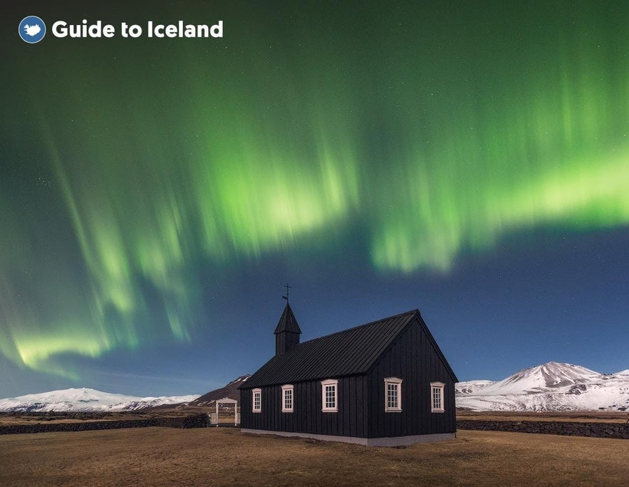 L'aurora boreale illumina il cielo sopra la chiesa nera di Budir