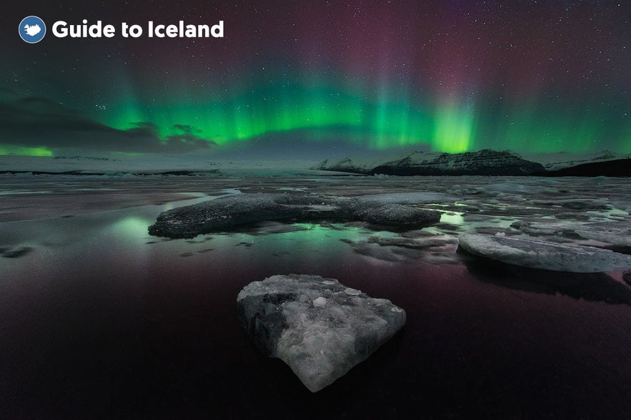 Laguna lodowcowa Jokulsarlon z zorzą polarną na niebie.