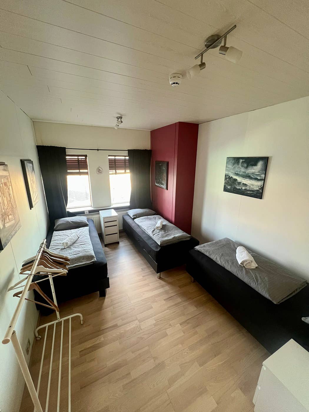 A triple room at Fisherinn - Hostel and Cultural Center with three single beds.