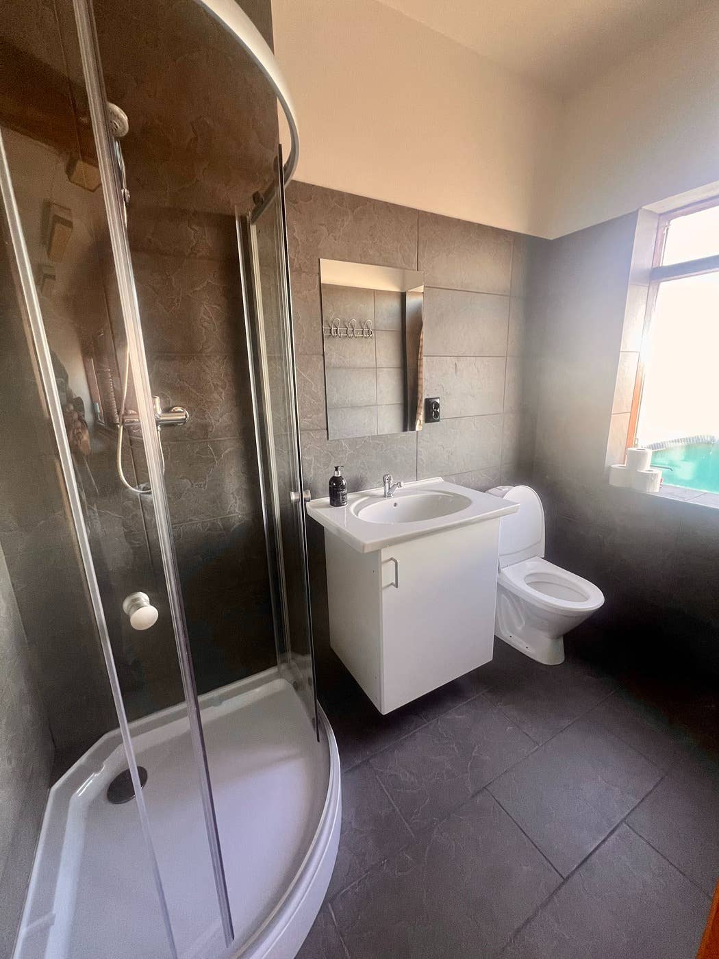 The shower area is enclosed in glass.