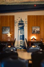 Obra de arte de un faro en la pared del comedor de Fisherinn.