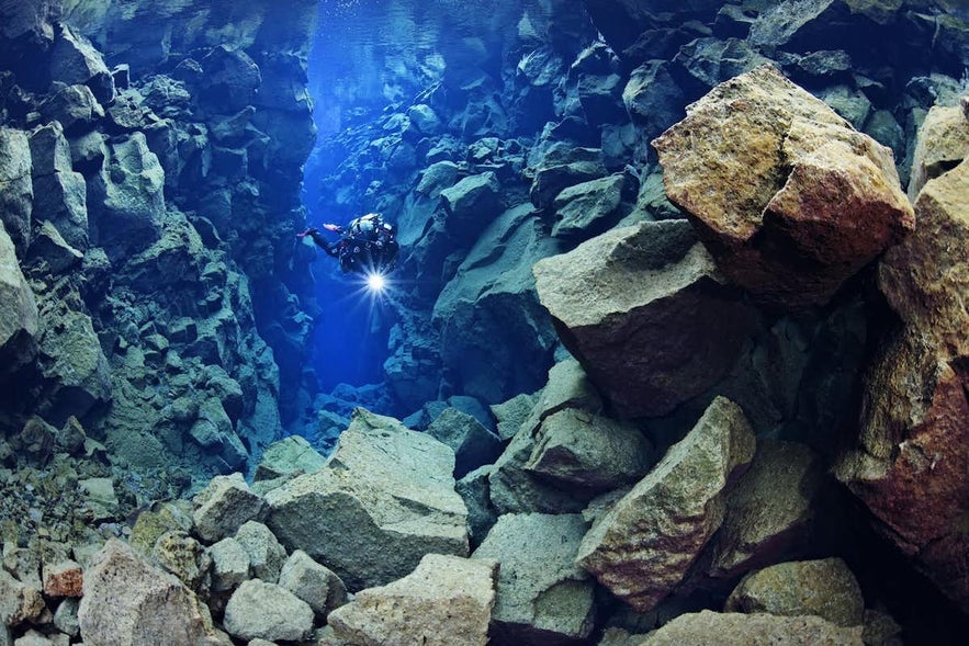 A scuba diver descends into the depths of Silfra Fissure.