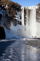 Skogafoss waterfall tumbles from a tall cliff in Iceland.