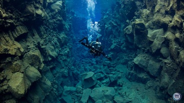 A scuba diver in Thingvellir National Park, with bubbles coming from the equipment.