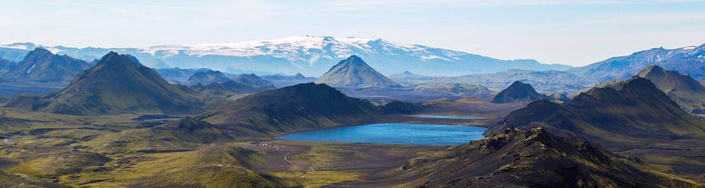 The spectacular landscapes of the Laugavegur Trail, with snow-capped mountains, beautiful lakes, and meandering rivers.