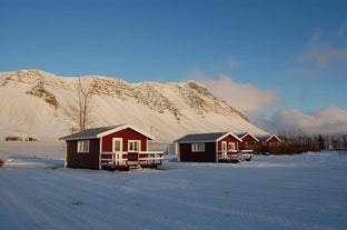 Outside view of the quaint red Moar Cottage #2 with the surroundings blanketed in snow.