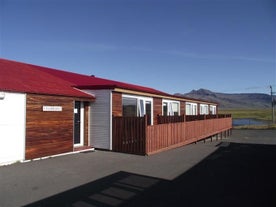 Exterior view of the studios at Laxarbakki, with private fenced-off patios and mountains nearby.