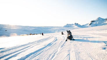 A group of travelers dashing across the mighty glacier of Langjokull in Iceland.