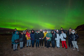 A group of tour joiners enjoying an intense display of the northern lights.