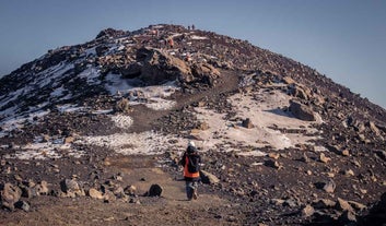 Menschen wandern auf einen Berg im Vulkangebiet der Halbinsel Reykjanes.