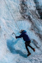 Person secured with a rope climbing Solheimajokull glacier.