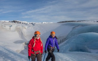 Twee mensen tijdens een gletsjerwandeling op de Solheimajokull-gletsjer in IJsland.