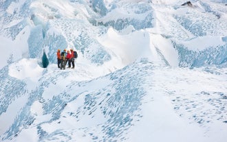 Een groep mensen tijdens een gletsjerwandeling met gids op de Solheimajokull-gletsjer.
