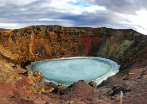 Il lago sul fondo del cratere vulcanico di Kerid, ghiacciato e circondato dai colori autunnali.