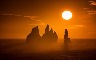 A golden sun, shining over the Reyjnisdrangar sea stacks on the South Coast of Iceland.