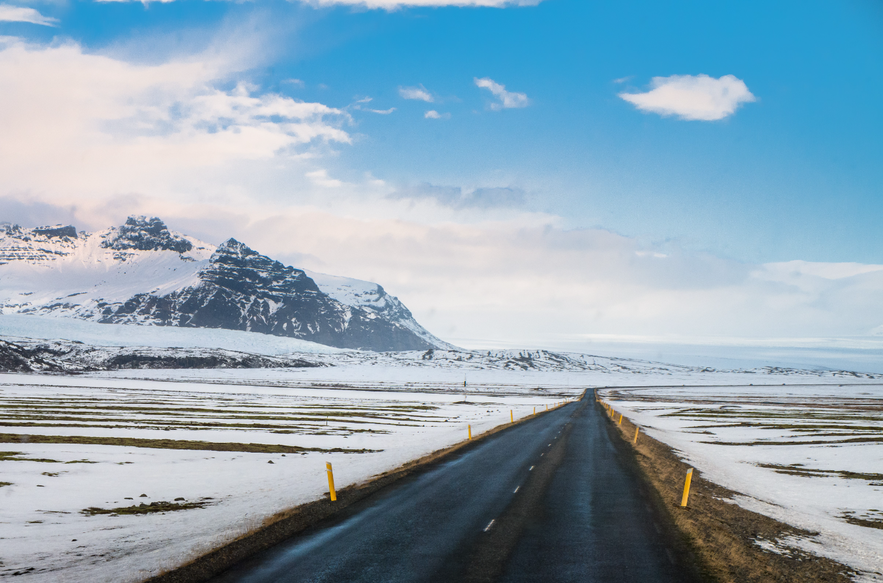 Road in Iceland with mountains and snow.