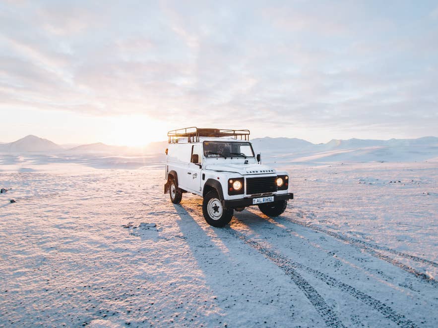 A 4x4 jeep on an open road in the Icelandic countryside