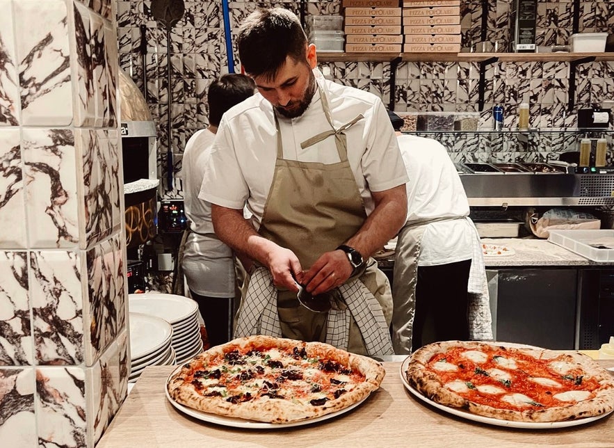 man making Pizza Popolare in Posthus food hall