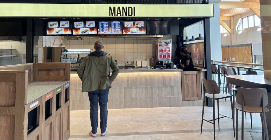 Man looking at the menu at Mandi Resturant in Reykjavik shopping hall