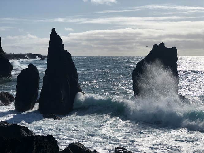 Powerful waves crashing against the sea stacks.