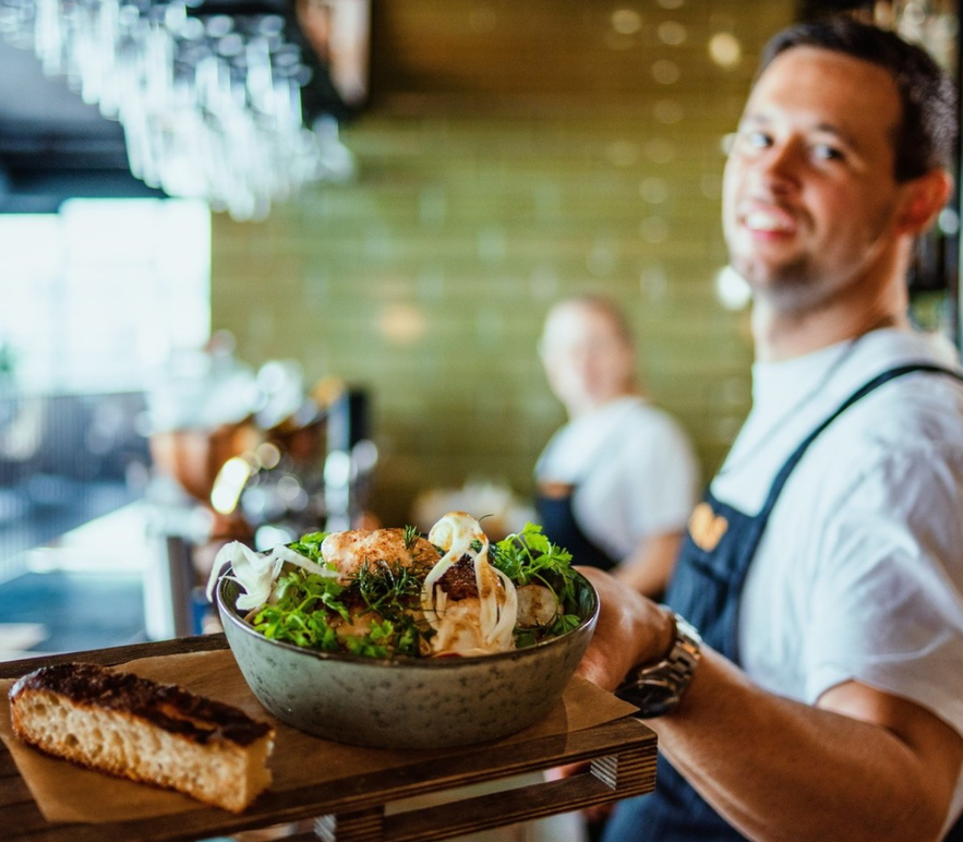 Man holding food from Hipstur restaurant in Hveragerdi