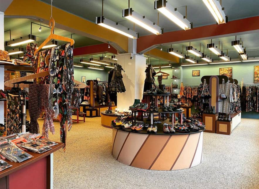 Interiøret i KronKron-butikken i Reykjavik, Island, hvor farverige designersko, mønstret tøj og eklektiske modevarer er udstillet i en livlig, retroinspireret indretning.