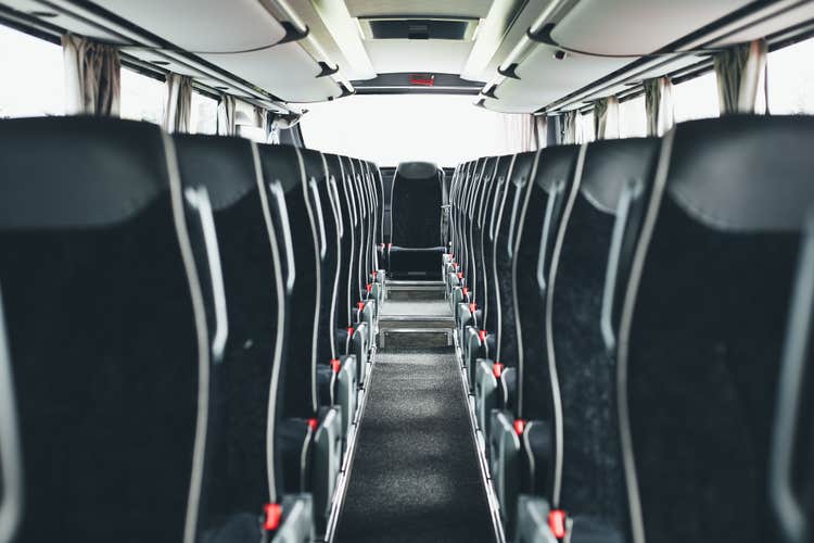 The interior of a bus seen with leather seats.