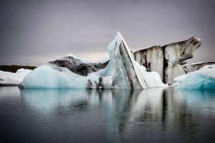 A large iceberg rises from the water of the Jokulsarlon glacier lagoon.