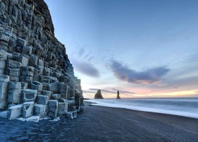 Basalt rock formations at Reynisfjara black sand beach at sunset.