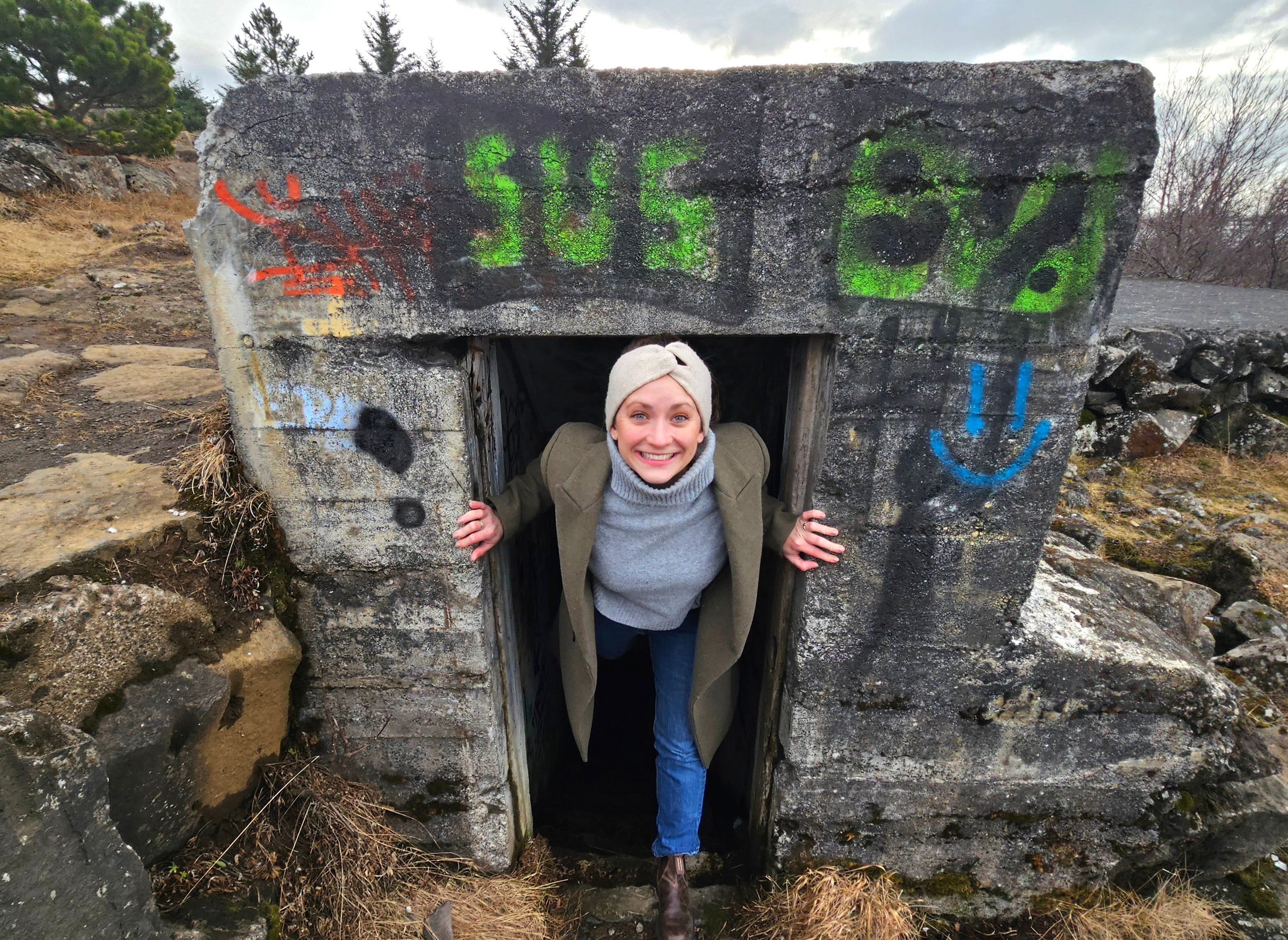 A woman climbing out of a bunker in Iceland.
