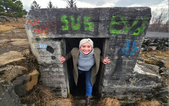 A woman climbing out of a bunker in Iceland.