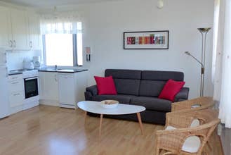 Sofa with a coffee table in front of it, the open plan kitchen is just visible in the background.
