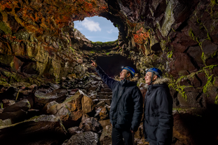 Travelers exploring the stunning lava cave of Raufarholshellir in Southwest Iceland.