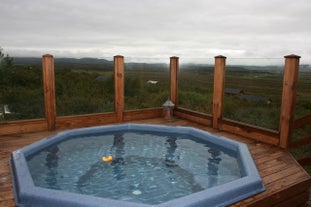 The hot tub terrace of the Solbakki Holiday Home overlooking the Icelandic countryside.