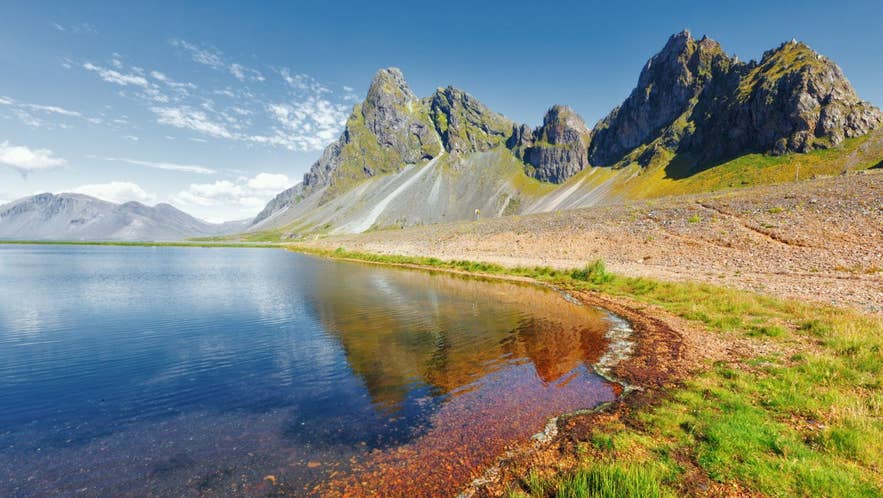 Coastal mountains and a shallow lagoon in Iceland, where the Gulf Stream shapes the island's cool maritime climate.