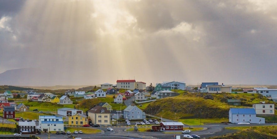 Colorful houses of Stykkisholmur in West Iceland under dramatic sunlight, a top choice for where to stay in Iceland.