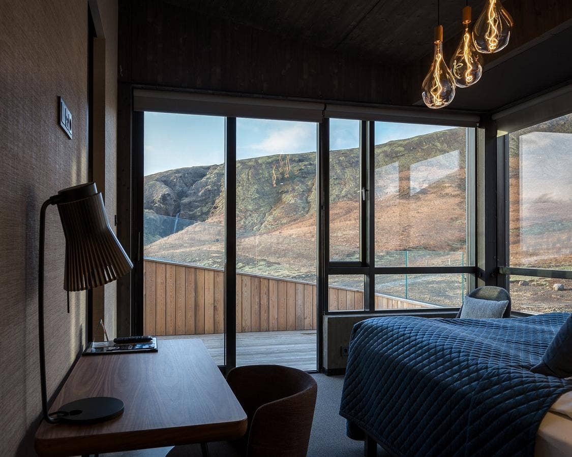The interior of a room at Fosshotel Glacier Lagoon, with a stunning mountain view visible through the window.