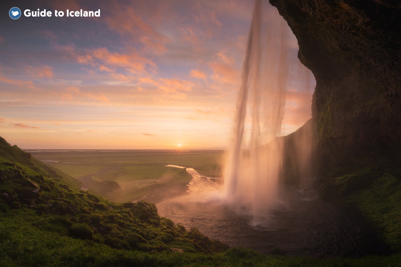 De Seljalandsfoss aan de zuidkust van IJsland, badend in het magische licht van de middernachtzon