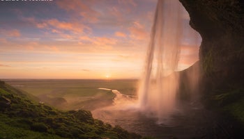 De Seljalandsfoss aan de zuidkust van IJsland, badend in het magische licht van de middernachtzon