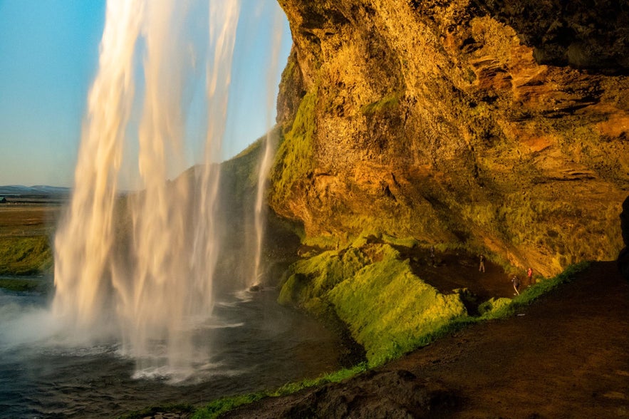 Wees voorzichtig op het gladde pad langs de Seljalandsfoss